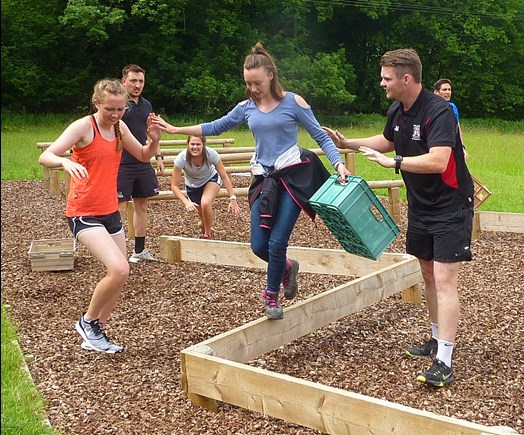 Young person taking part in a balance challenge obstacle course.