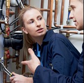 Young person taking part in plumbing /heating work experience pictured with tools while being instructed by an employer