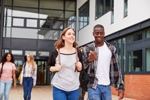 Two young people walking out of a further/higher education setting 