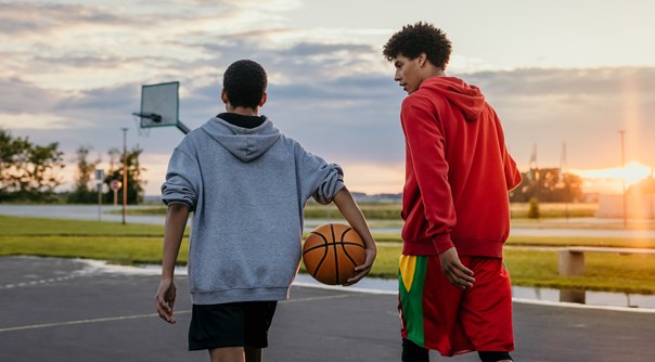 Two boys playing basketball outside