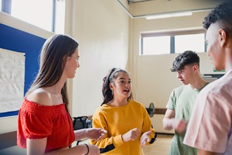 Group of young people standing in a hall and talking.