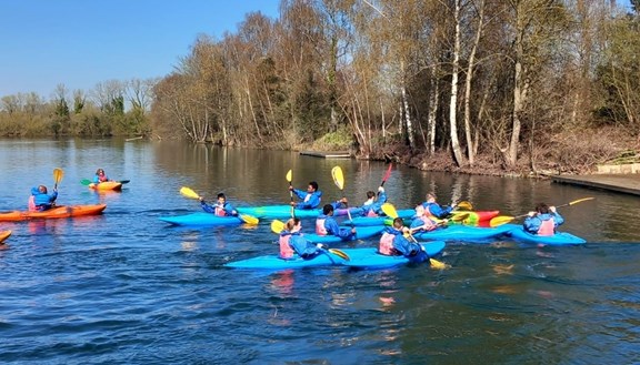 Young people kayaking on a lake as part of the of activities on offer at the Easter HAPpy  programme.