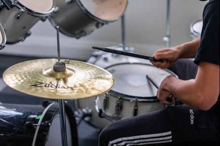 Young person playing drums.